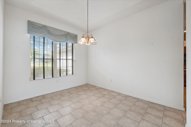 tiled empty room with a chandelier