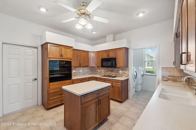 kitchen featuring a center island, black appliances, sink, ceiling fan, and separate washer and dryer