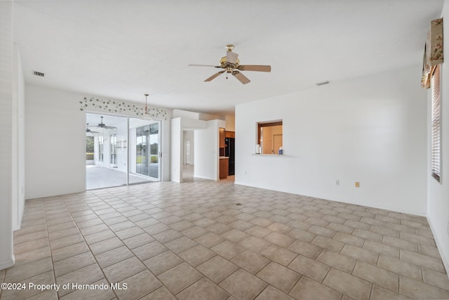 unfurnished living room featuring ceiling fan with notable chandelier