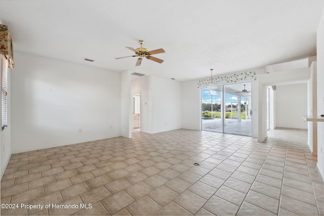 tiled empty room featuring ceiling fan