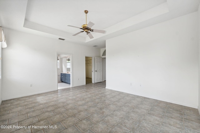 unfurnished room with a raised ceiling and ceiling fan