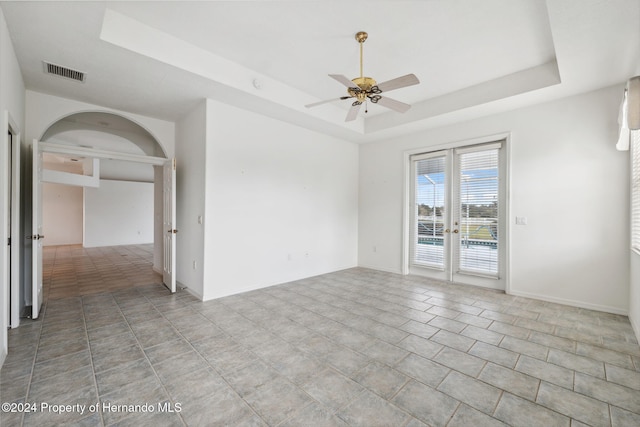 spare room featuring ceiling fan, french doors, and a tray ceiling