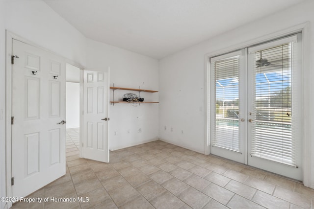 empty room with french doors and light tile patterned flooring