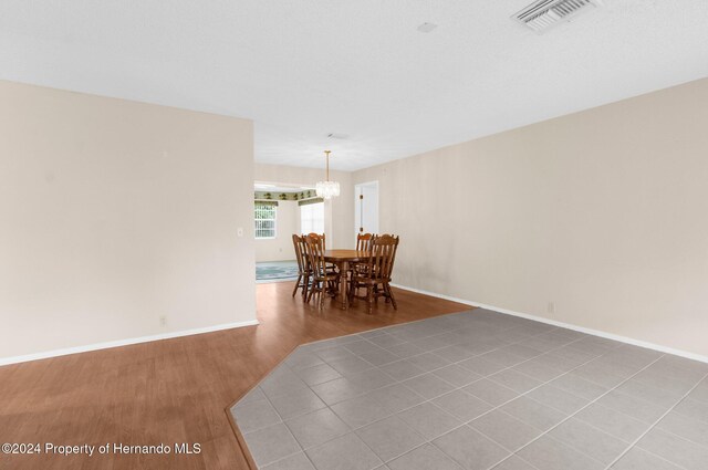 dining space featuring hardwood / wood-style flooring and a notable chandelier