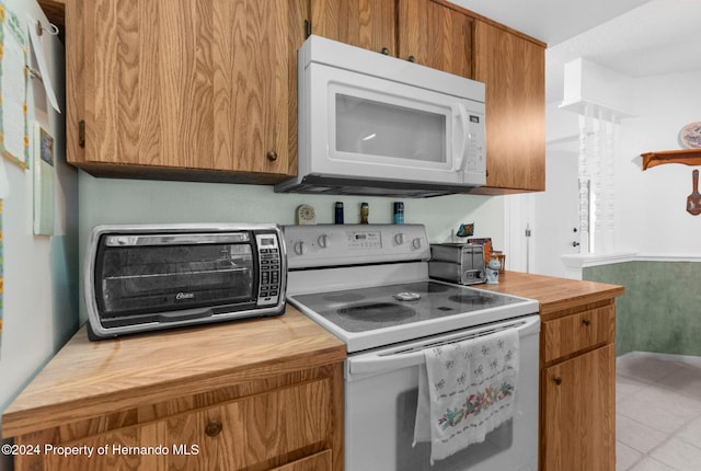 kitchen with white appliances and light tile patterned floors