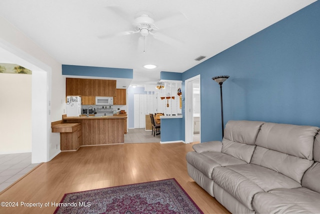 living room featuring ceiling fan and light hardwood / wood-style flooring