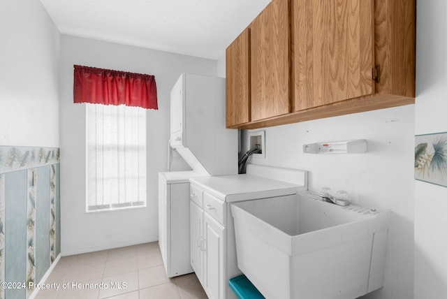 washroom with hookup for a washing machine, light tile patterned floors, and cabinets