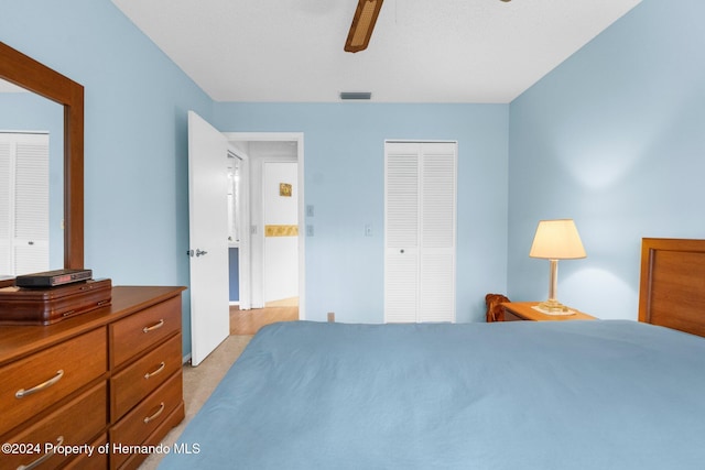 bedroom with ceiling fan, light colored carpet, and a closet