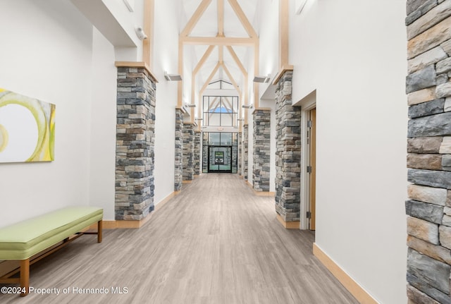 corridor featuring a high ceiling and hardwood / wood-style floors