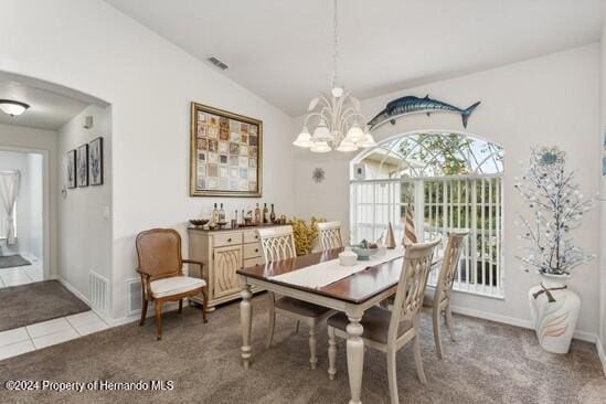 carpeted dining area with vaulted ceiling and a chandelier