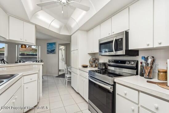 kitchen with decorative backsplash, appliances with stainless steel finishes, ceiling fan, light tile patterned floors, and white cabinetry