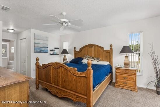 bedroom featuring ensuite bathroom, ceiling fan, light colored carpet, and a closet