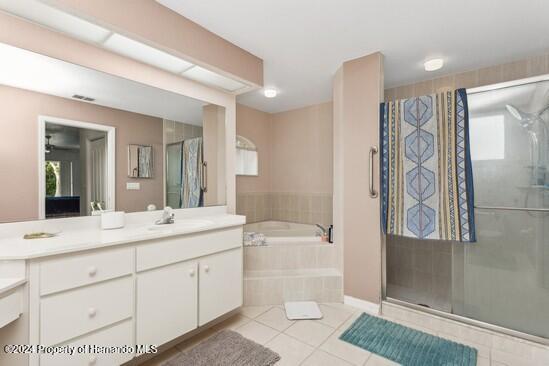 bathroom featuring tile patterned flooring, vanity, and independent shower and bath