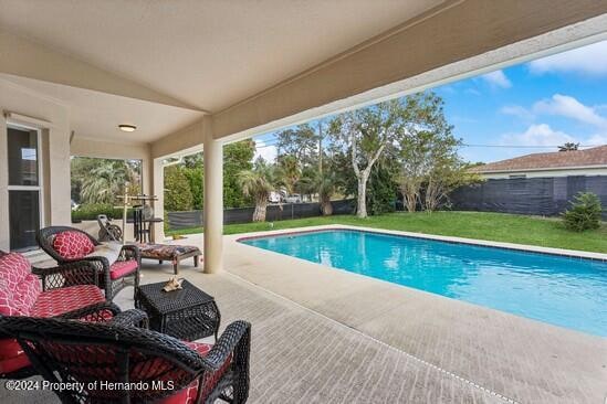 view of pool featuring a lawn and a patio