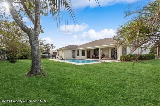 back of property featuring a yard and a patio