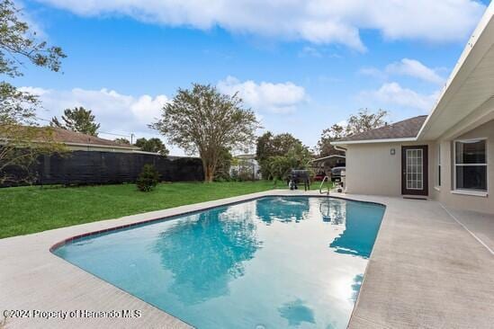 view of pool with a yard and a patio area