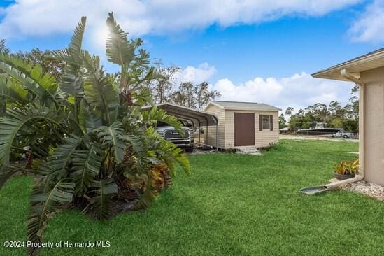 view of yard with a storage unit and a carport