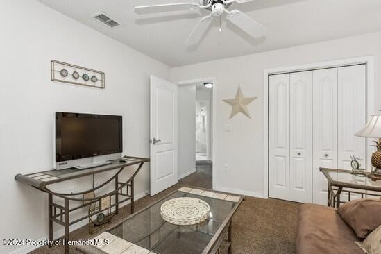 carpeted living room with ceiling fan