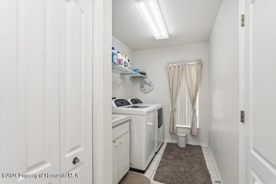 laundry room with light tile patterned floors and separate washer and dryer