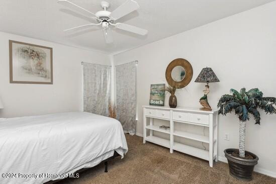 bedroom with dark carpet and ceiling fan