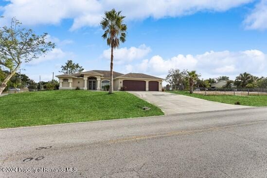 ranch-style home with a front lawn and a garage