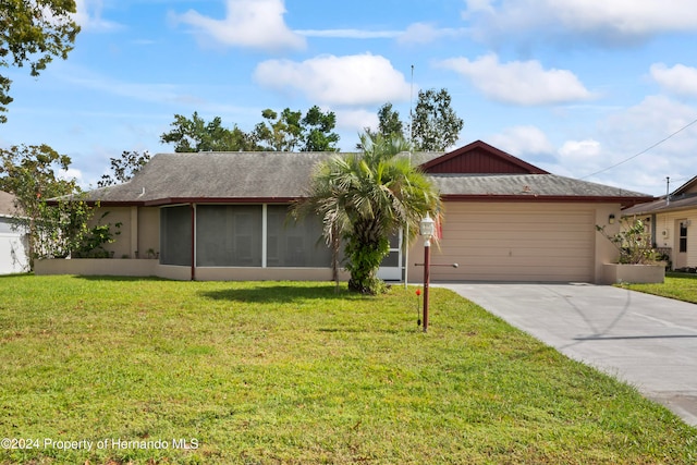 ranch-style home with a sunroom, a front lawn, and a garage