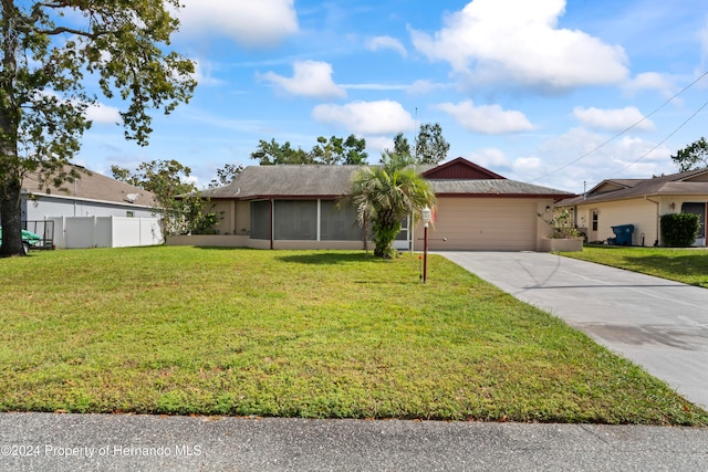 ranch-style home featuring a garage and a front lawn