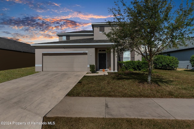 view of front of property with a yard and a garage