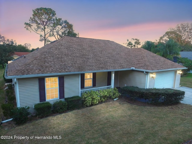 ranch-style home featuring a yard and a garage