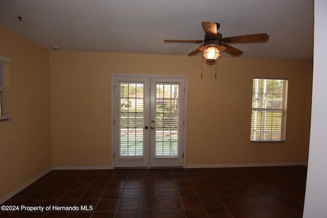 interior space featuring dark tile patterned flooring, ceiling fan, and french doors