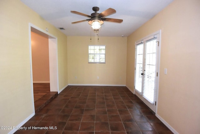 empty room featuring ceiling fan, a healthy amount of sunlight, and french doors