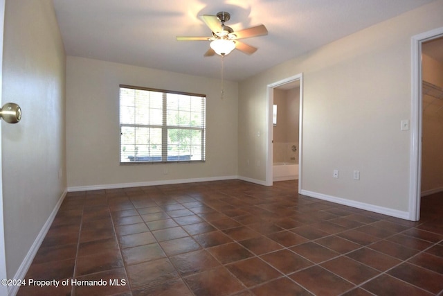 tiled spare room with ceiling fan