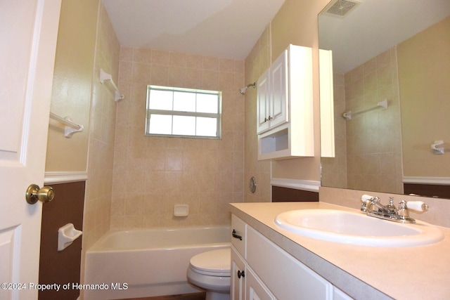 full bathroom featuring vanity, tiled shower / bath combo, and toilet