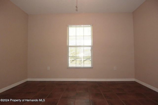 spare room featuring dark tile patterned floors