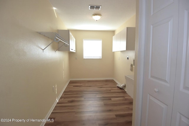 laundry area featuring hookup for an electric dryer, cabinets, and dark wood-type flooring