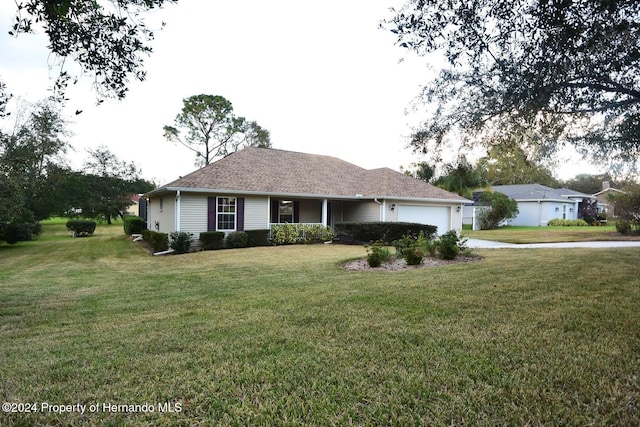 ranch-style house featuring a front lawn and a garage