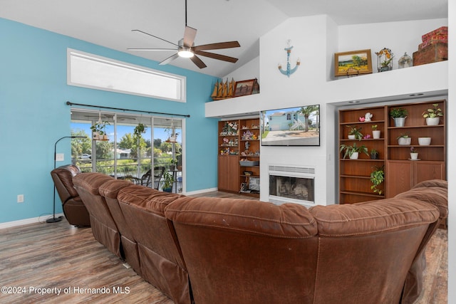 living room featuring hardwood / wood-style floors, ceiling fan, and high vaulted ceiling