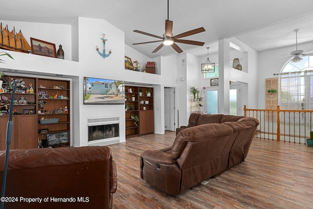 living room featuring high vaulted ceiling, wood-type flooring, a textured ceiling, and ceiling fan