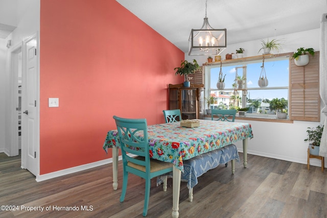 dining room featuring lofted ceiling, an inviting chandelier, and hardwood / wood-style flooring