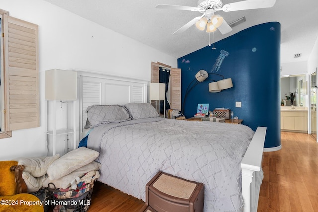 bedroom featuring ceiling fan, a textured ceiling, vaulted ceiling, and light hardwood / wood-style floors