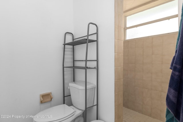 bathroom with toilet and a tile shower