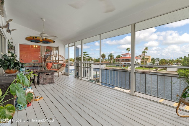 sunroom with a water view and ceiling fan