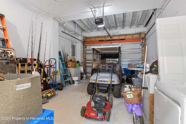 garage with electric panel, washer / clothes dryer, and a garage door opener