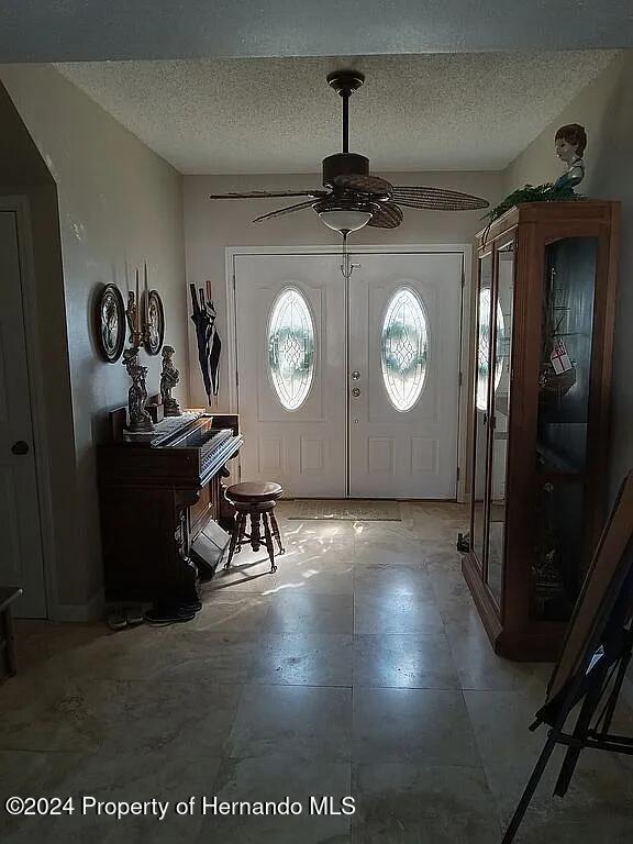 3519 Cobia Dr, Hernando Beach, FL 34607 - foyer entrance with ceiling fan and a textured ceiling