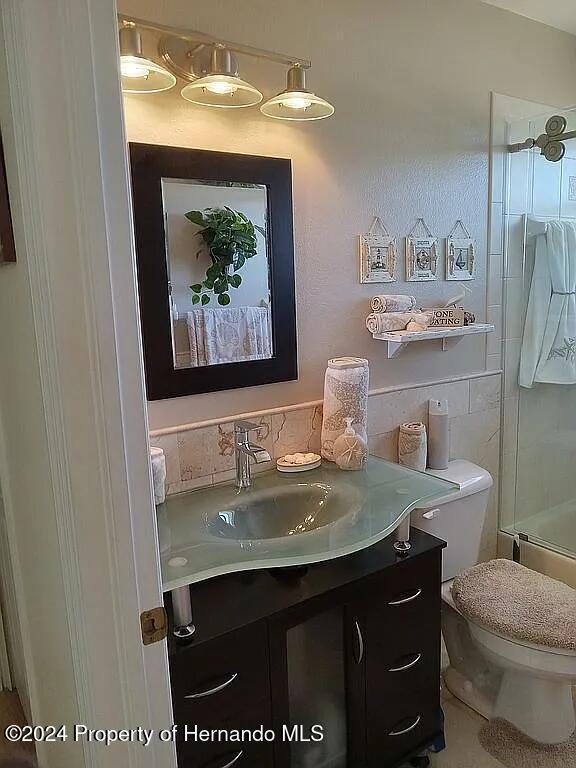 3519 Cobia Dr, Hernando Beach, FL 34607 - full bath with vanity, toilet, and tile walls