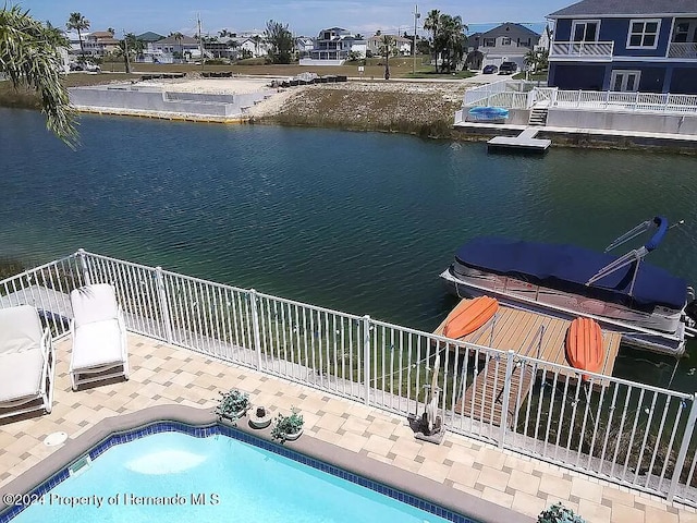 view of swimming pool with a dock and a water view