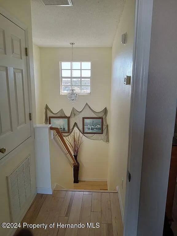 3519 Cobia Dr, Hernando Beach, FL 34607 - stairway with a chandelier, baseboards, and wood finished floors