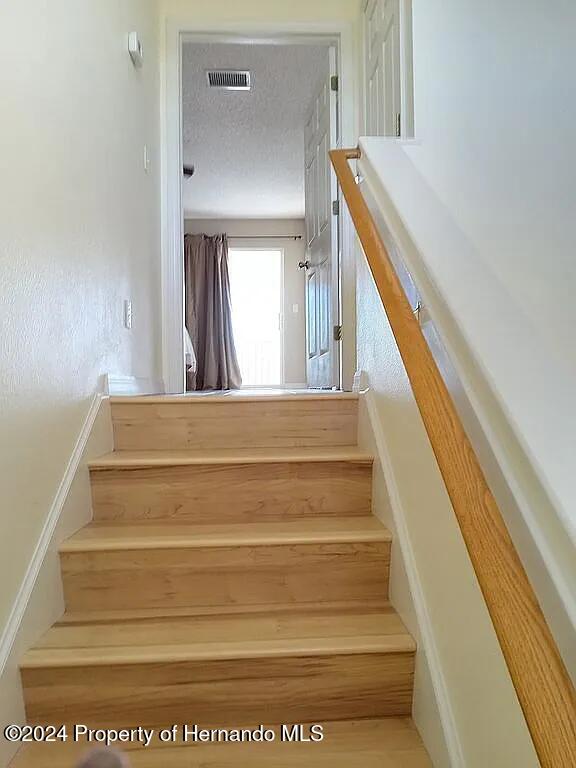 stairs with a textured ceiling