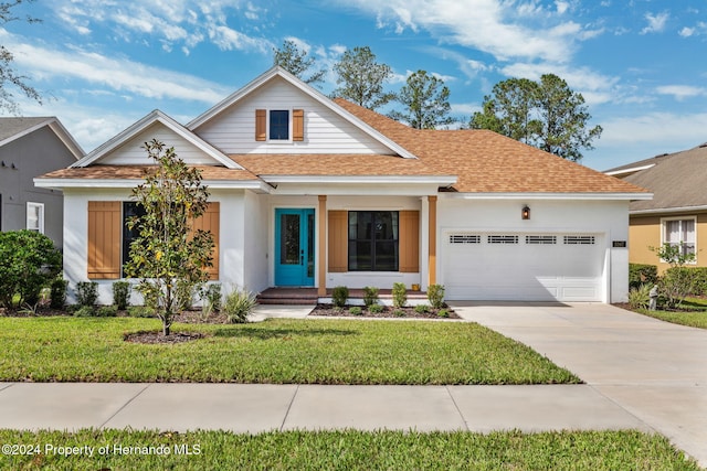 view of front of home featuring a garage, a porch, and a front yard