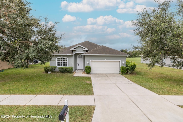 ranch-style home featuring a garage and a front lawn